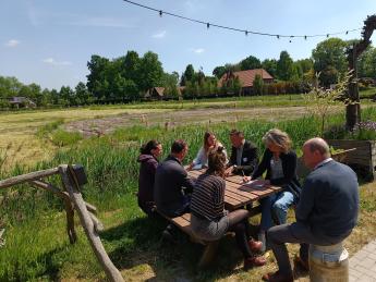 Mensen die buiten aan een tafel zitten