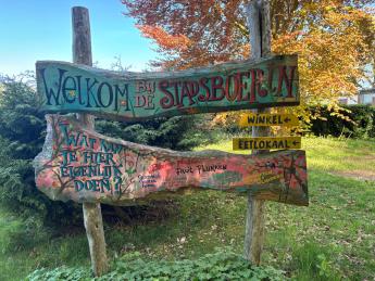 Houten bord met 'Welkom bij de Stadsboerin' op genoteerd.