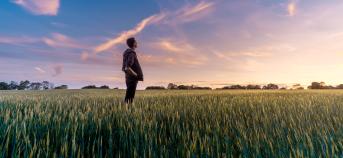 Landbouwer kijkt naar lucht in zijn veld