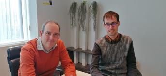 Kevin Grauwels en Wouter Peeters van de Vlaamse Landmaatschappij zitten op een stoel aan een tafel