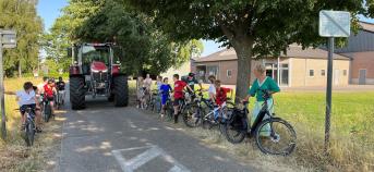 Kinderen op de fiets in straat, met tractor in het midden (copyright Radio2)