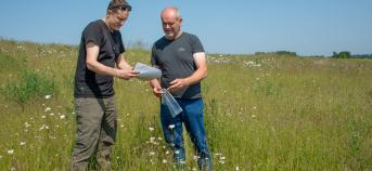 Landbouwer en bedrijfsplanner VLM op een veld