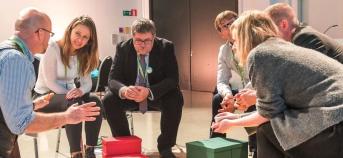 Mensen zitten samen na te denken en buigen voorover